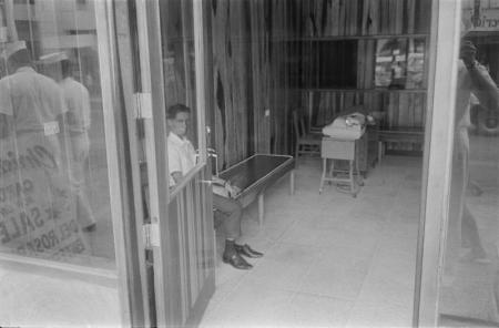 1969 PHillipines man sitting shop shoe off.jpg